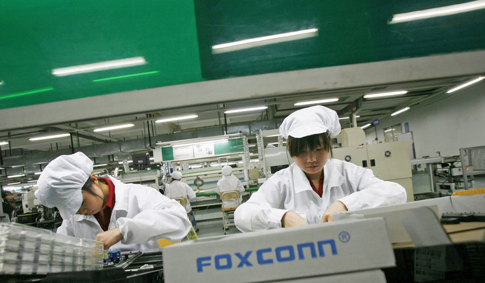 File photo of employees working inside a Foxconn factory in the township of Longhua