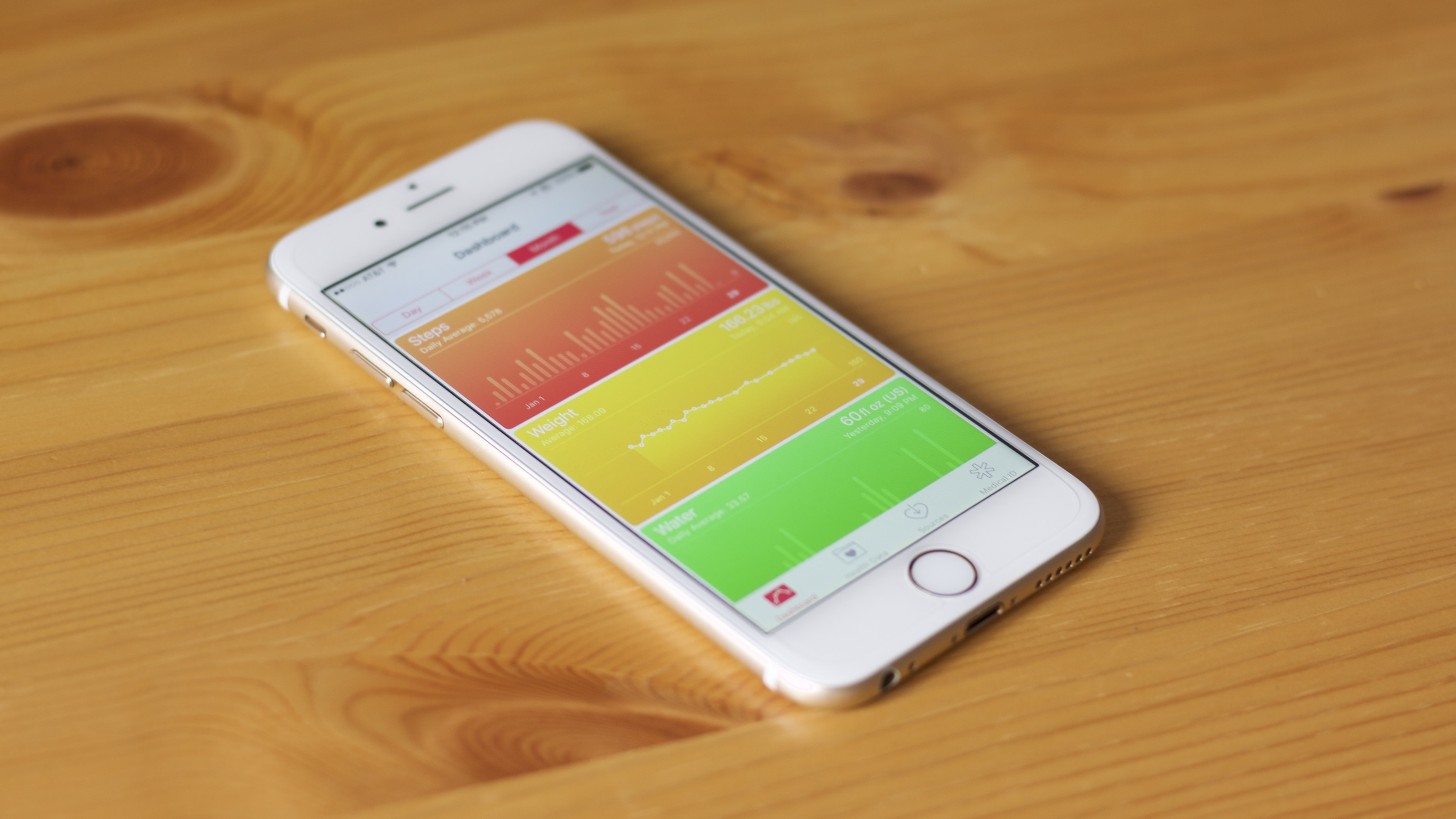 iPhone on table showing Health app screen listing out steps, weight, and water