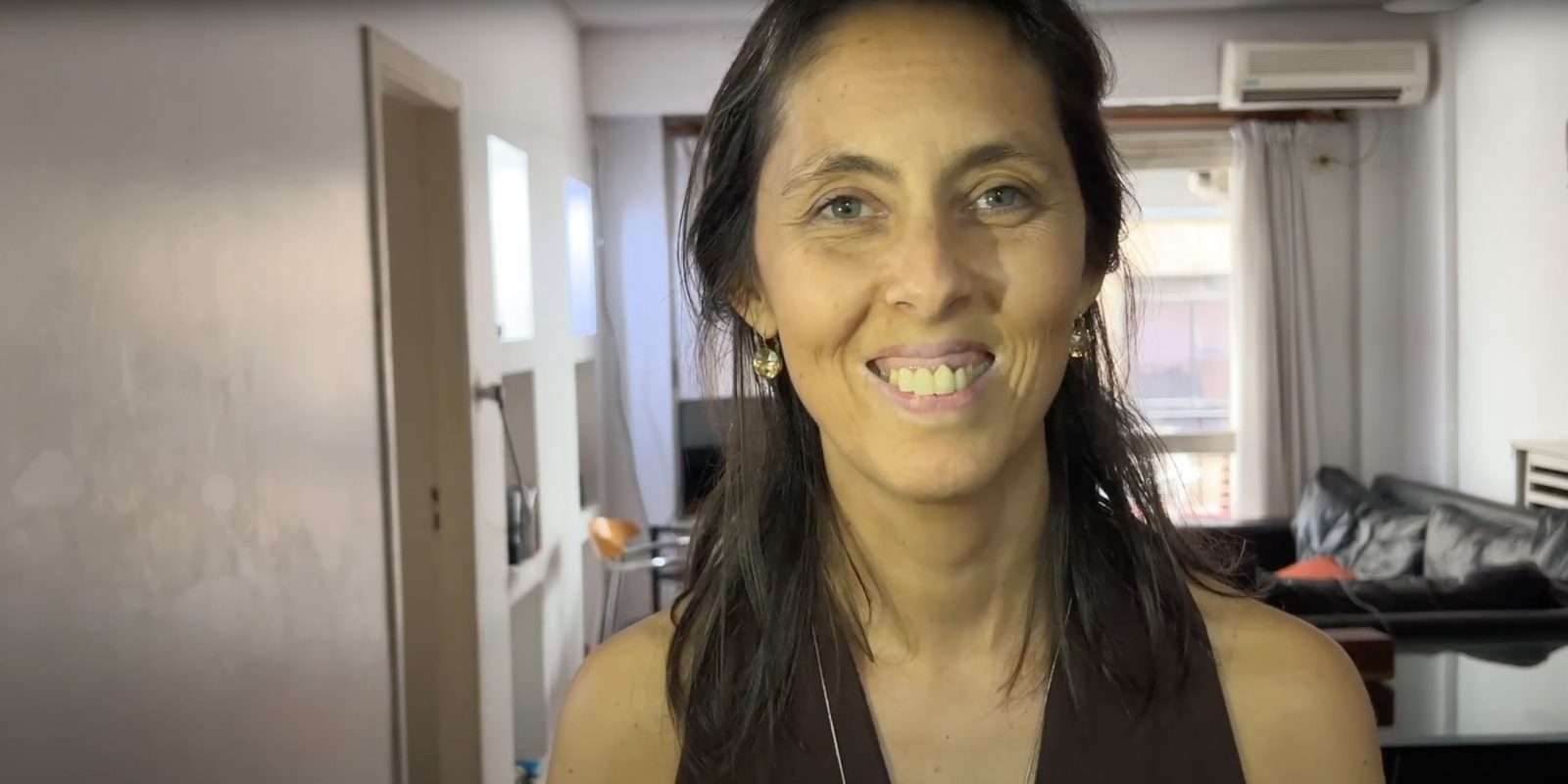 Screengrab of a video interview, woman in small apartment | Unexpected iPhone video shoot, 7000 miles from my camera kit