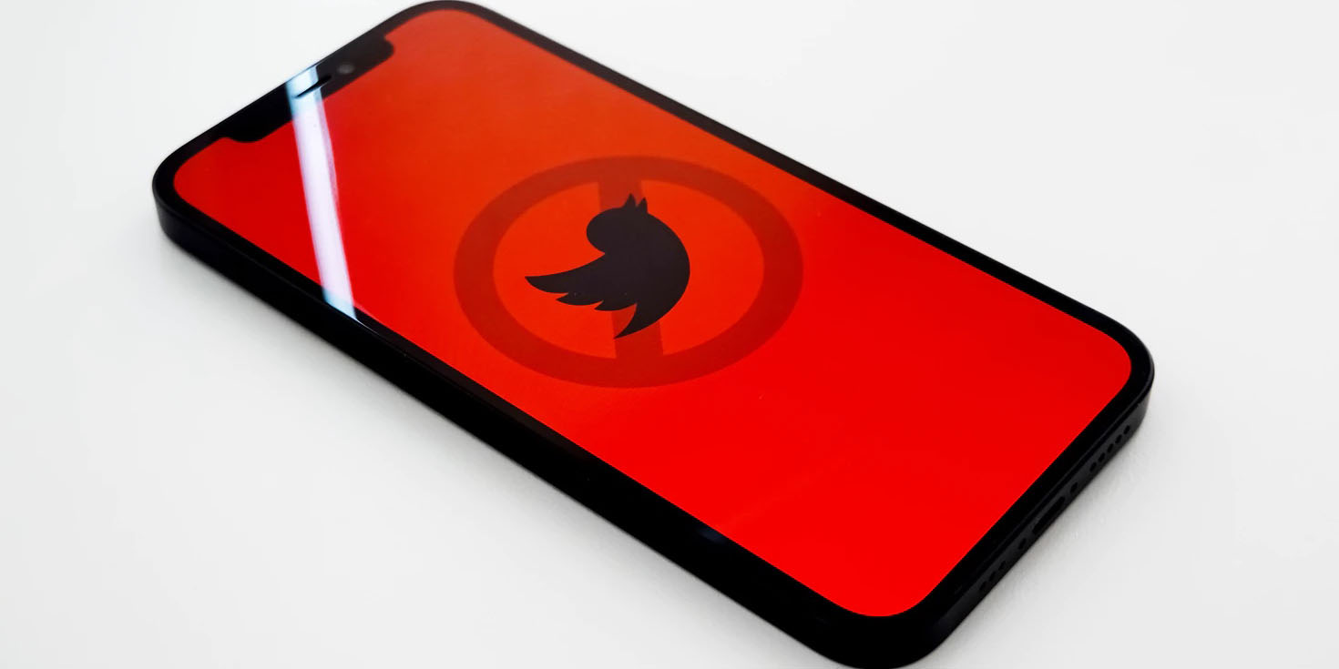 iPhone with Twitter logo crossed out | Elon Musk Twitter deal on hold, with three theories