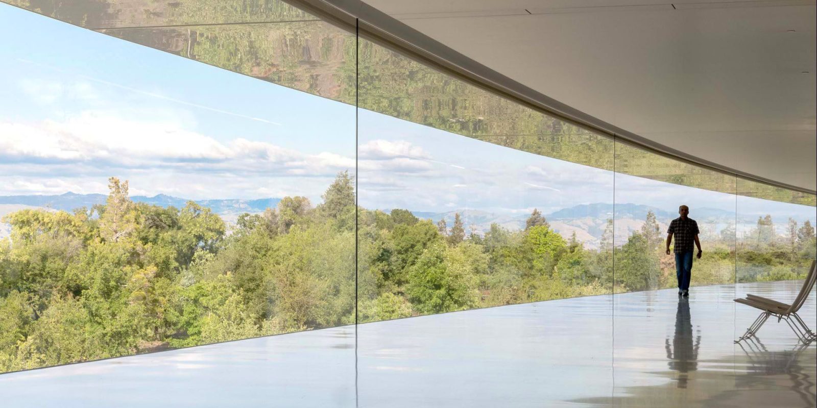 Apple layoffs avoided | Man walking inside Apple Park campus