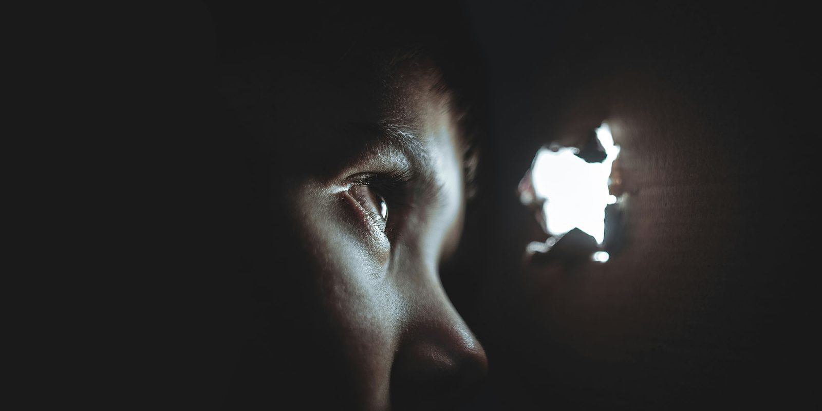 Ads and push notifications used to on iPhone users | Eye looking through a hole in a wall