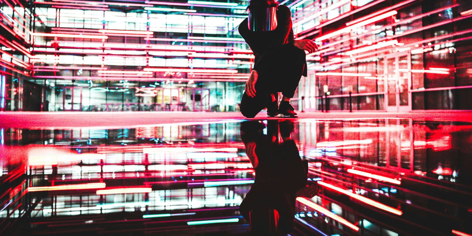 Grok AI chatbot | Abstract image of masked figure against colorful background