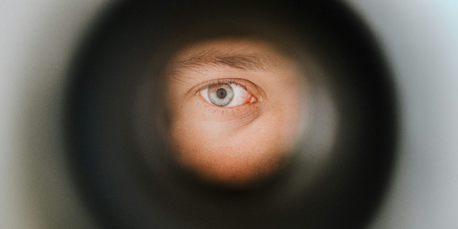 TikTok national security briefing | Eye looking through a hole in a wall