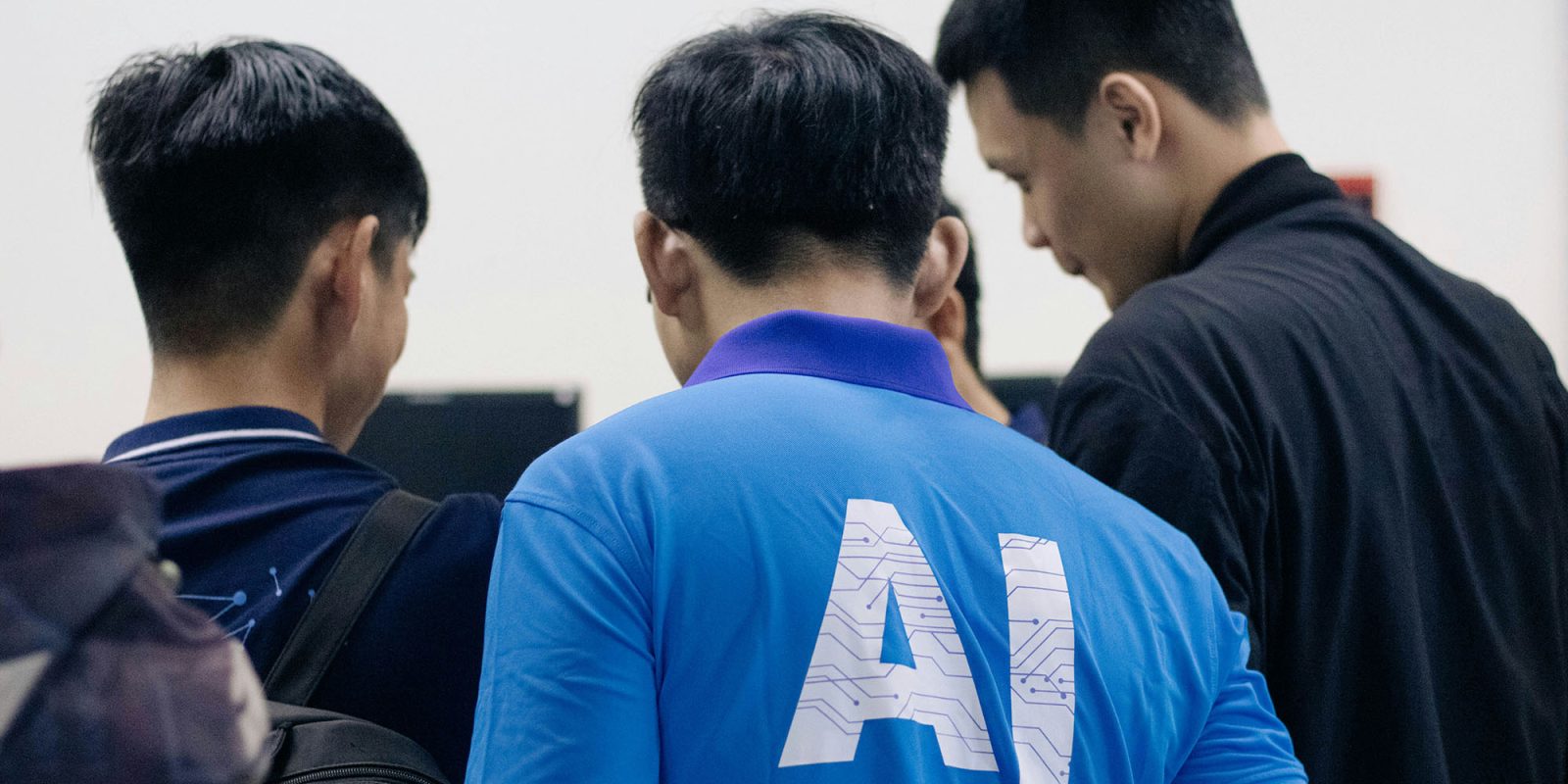 Anger as Meta AI added to WhatsApp, raising fears it wants to use messages for training | Man wearing AI t-shirt looking over the shoulders of a group of people