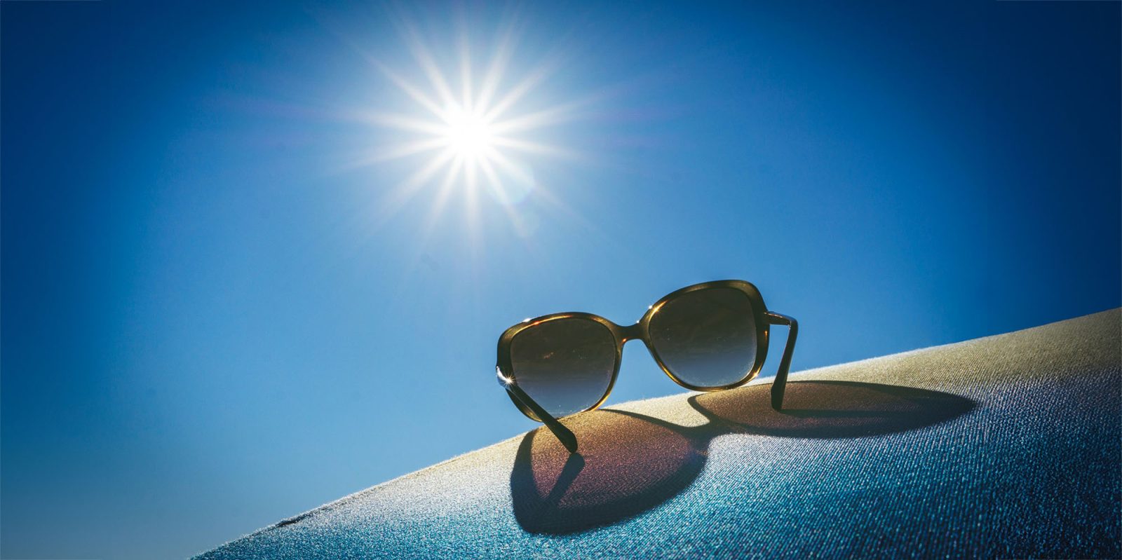 Apple smart glasses only make sense if two things are true | Sunglasses resting on a pair of jeans shot into the light