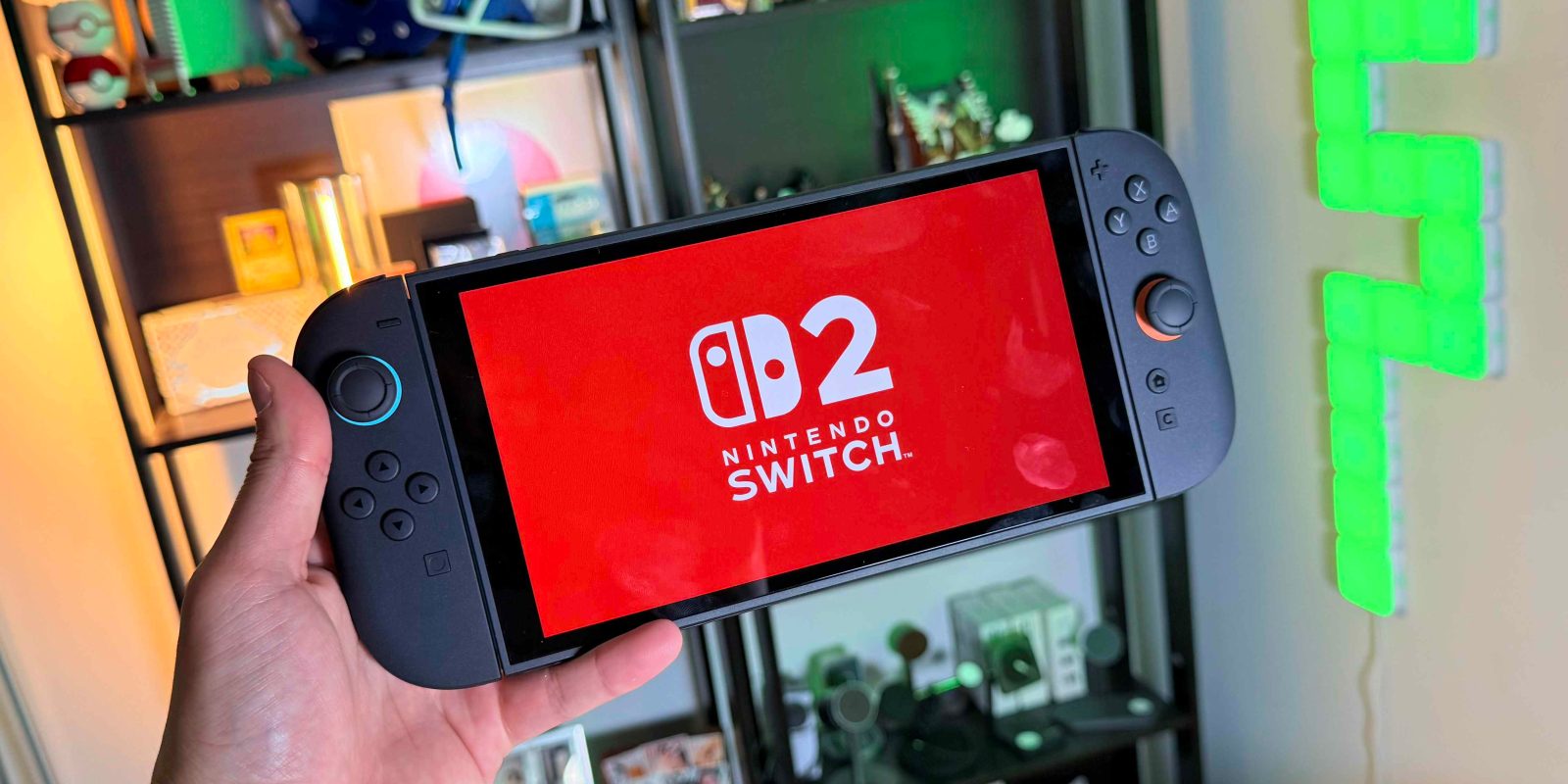 A hand holding a video game console