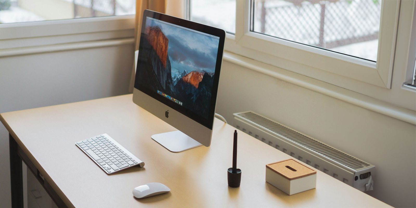 This theory about Jony Ive's AI hardware device seems increasingly likely | A desk with iMac, keyboard, mouse, pen stand, and box