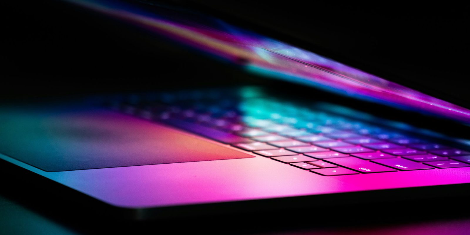 Here are the eight Apple security layers protecting your data | Partly-open MacBook with colorful reflections