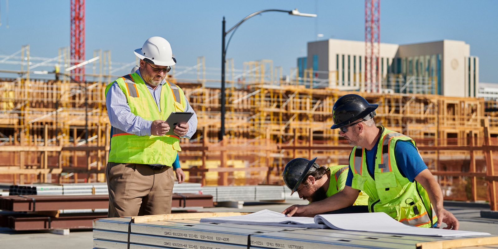 Amazon and Apple best deliver on affordable housing promises, as other tech giants falter | Construction workers study plans