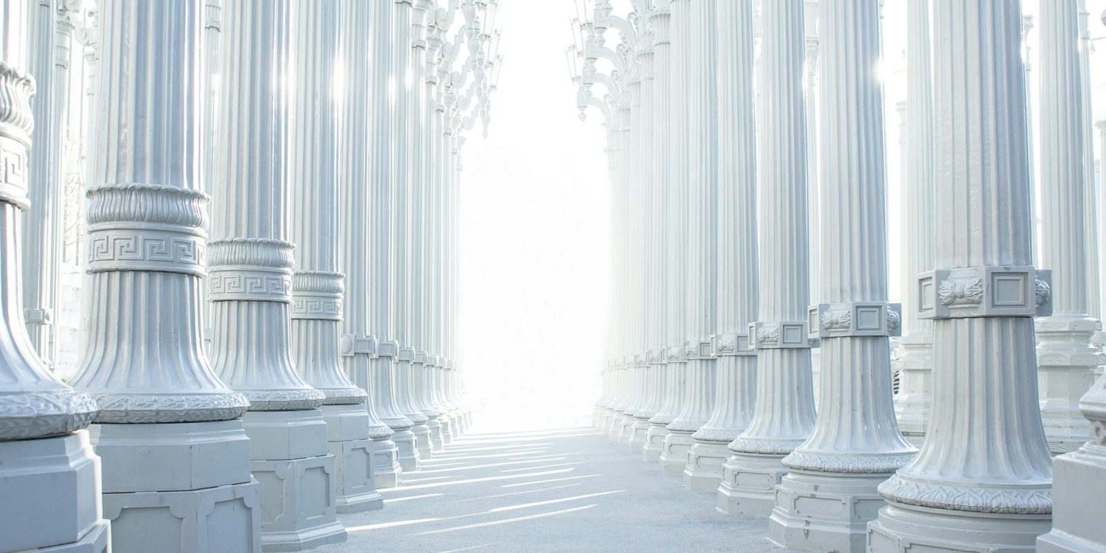 Apple vs EU war of words continues – 'intrusive burdens' v 'locked-in users' | High-key image of white pillars