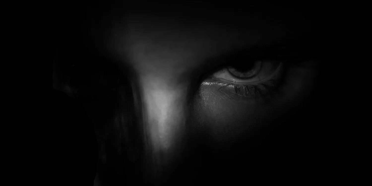 The British government is still insisting Apple must create a backdoor into iCloud | Low-key photo of eyes peering from the darkness