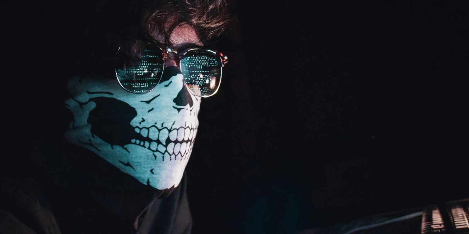 2B email addresses and 1-3B passwords compromised in multiple data breaches | Image shows a masked man with code reflected in his glasses