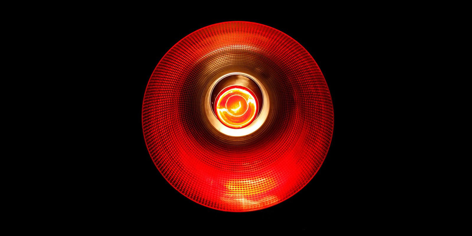 As Apple reboots its AI work, OpenAI ramps up the pressure by declaring 'code red' | Photo shows close-up of a red light reminiscent of HAL