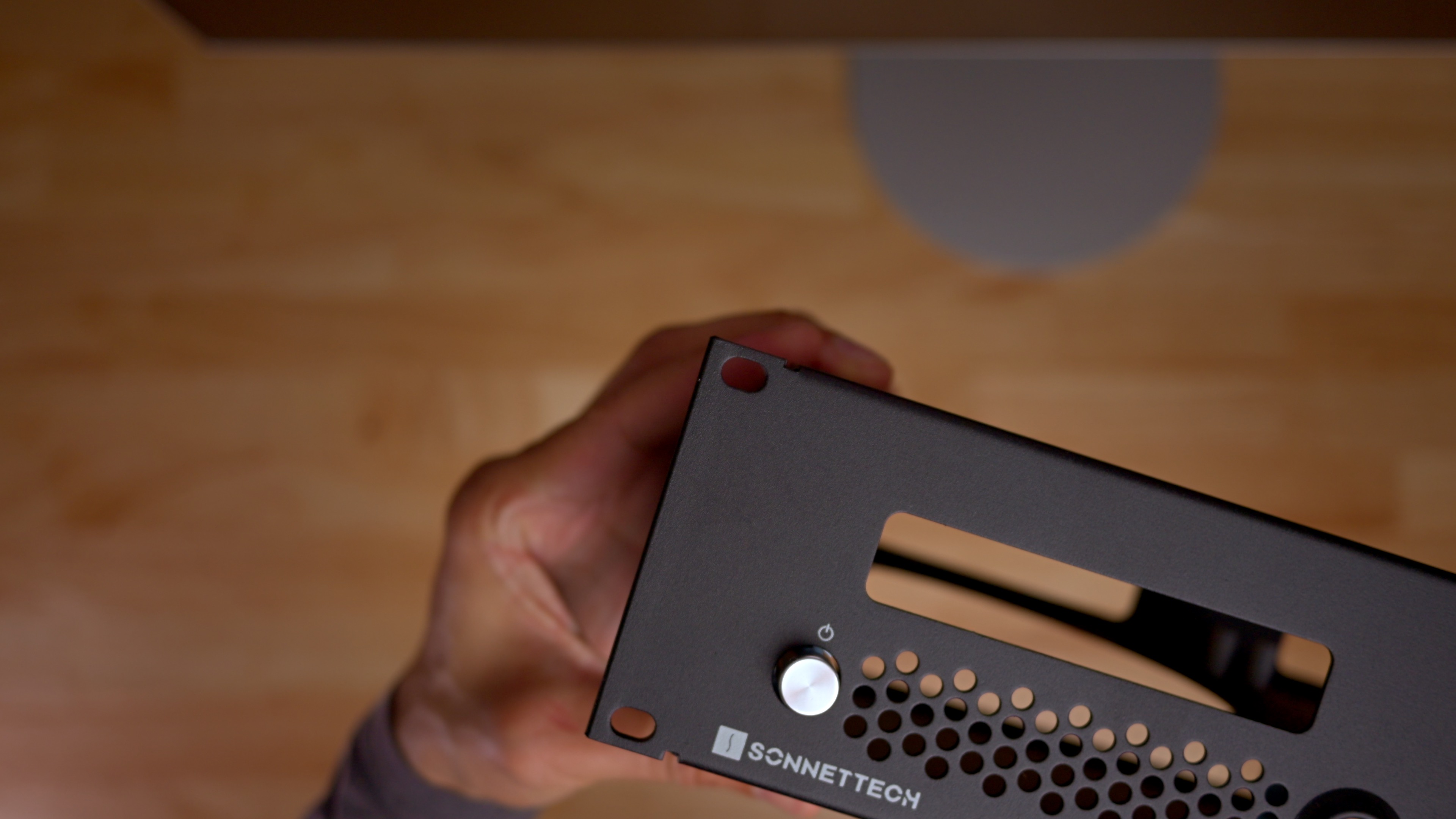Sonnet RackMac mini enclosure in hand with power button
