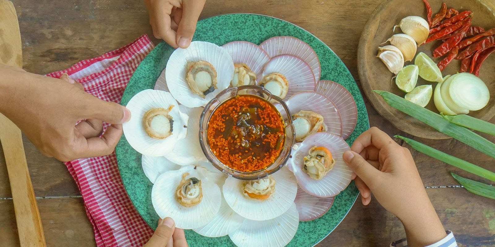 'Double-dipping' dispute over Qualcomm iPhone chips finally ends | Close up of hands reaching for food with a dip in the center of the plate