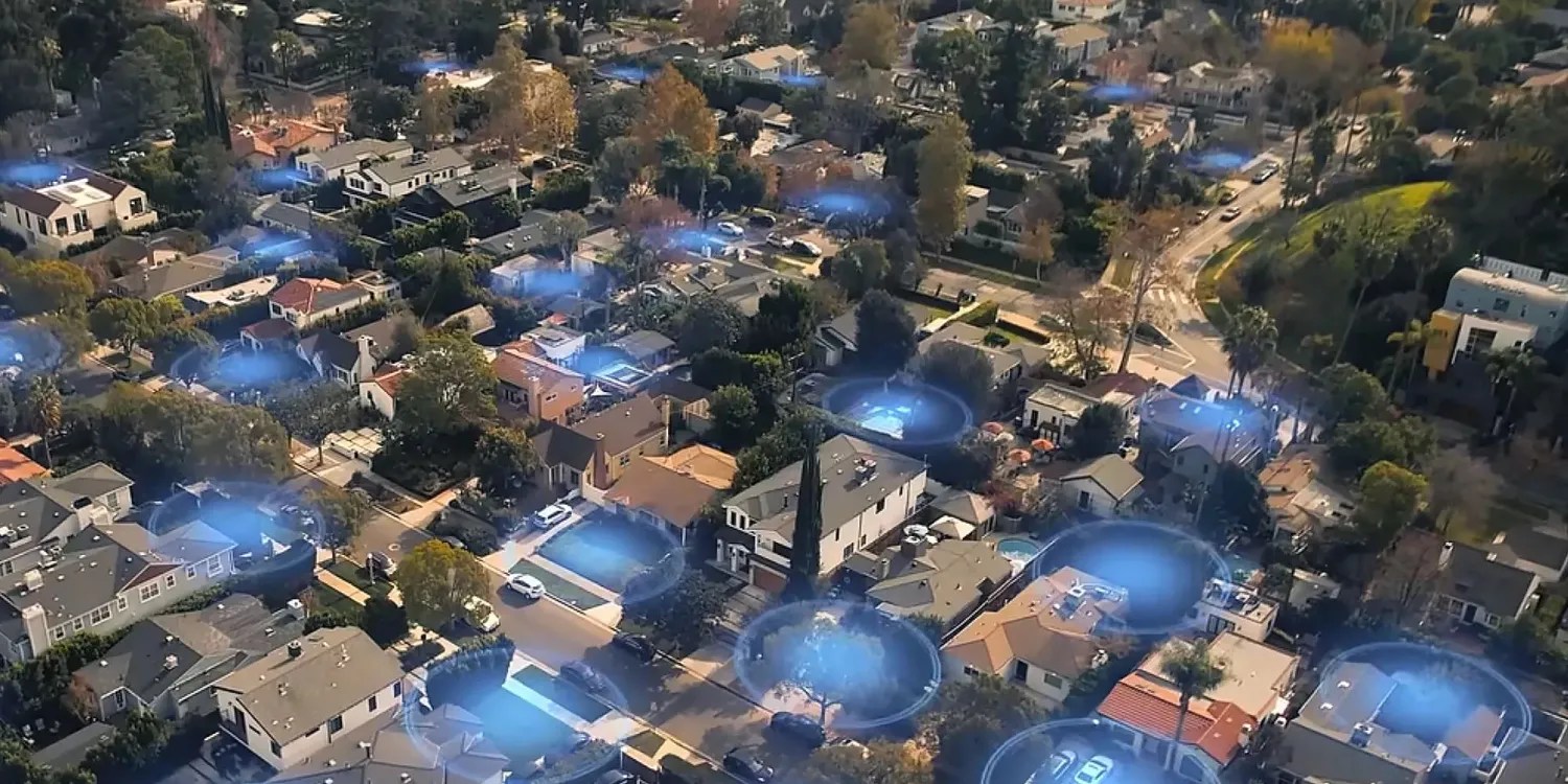 Leaked email proves Ring intended to use surveillance feature for people as well as dogs | Promotional image showing blue surveillance zones filling a neighborhood